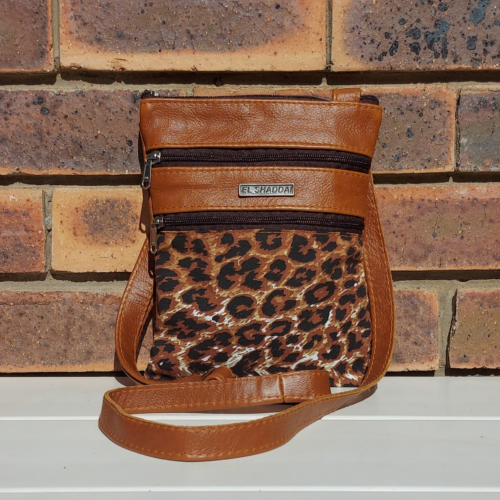 Genuine leather and leopard print fabric sling bag.