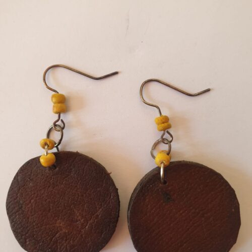 Brown round earrings with yellow beads.